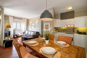 a kitchen and living room with a wooden table and chairs at Villa Apple in Vale do Lobo