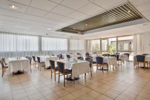 een eetkamer met witte tafels en stoelen bij Crisol Quality Reus in Reus