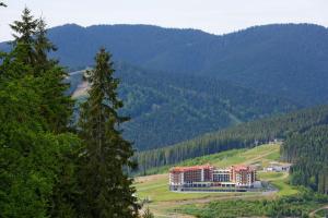 a building in the middle of a mountain with trees at Radisson Blu Resort Bukovel in Bukovel