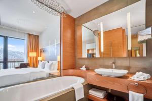 a bathroom with a bed and a bath tub and a sink at Radisson Blu Resort Bukovel in Bukovel +209 photos