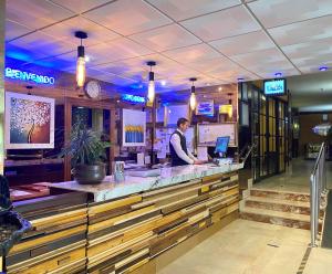 un hombre parado en un bar en un restaurante en Apartamentos La Jabega en Fuengirola