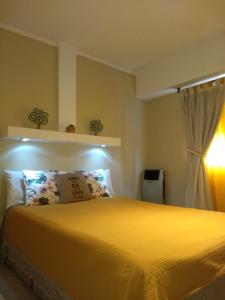 a bedroom with a yellow bed and a window at San Clemente Aventura in San Clemente del Tuyú