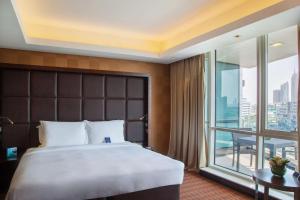 1 dormitorio con 1 cama grande y balcón en Radisson Blu Hotel, Dubai Media City en Dubái