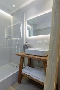 a bathroom with a sink and a mirror and a tub at Boho Sapiens Blue Perlite in Adamas