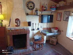 een woonkamer met een open haard en een wastafel bij Accogliente casa in pietra in borgo medievale in Serra Pistoiese