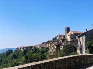 uitzicht op een stad vanaf een heuvel met huizen bij Accogliente casa in pietra in borgo medievale in Serra Pistoiese