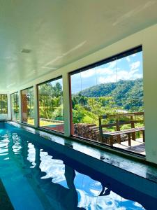 a house with a swimming pool with a view at Chalés na Fazenda Ritmos da Terra in Angelina