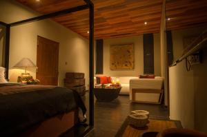 a bedroom with a bed and a couch and a chair at Stone House, Kandy in Kandy