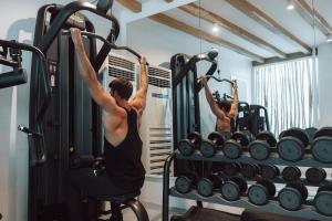 a woman doing a pull up in a gym at Mykonos Ammos Hotel - Small Luxury Hotels of the World in Ornos