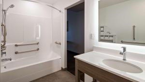 un bagno con lavandino, vasca e doccia di The Forge Hotel BW Signature Collection ad Anaconda