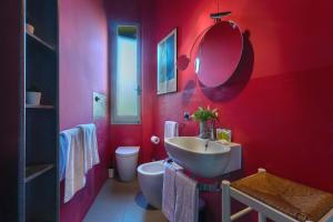 a red bathroom with a sink and a toilet at Saffi Huge Apartment a pochi passi dall'Ospedale in Bologna +14 photos