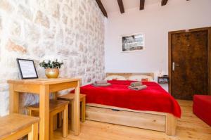 a bedroom with a bed with a red blanket at Eddie's Sea View Rooms Old Town in Dubrovnik
