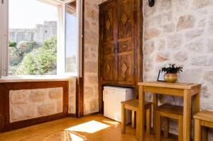 Zimmer mit einem kleinen Tisch und einem Fenster in der Unterkunft Eddie's Sea View Rooms Old Town in Dubrovnik