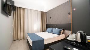 a hotel room with a bed and a television at OPERA Hotel Antalya in Antalya