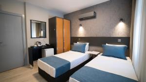 a hotel room with two beds with blue pillows at OPERA Hotel Antalya in Antalya