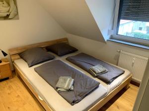 een bed met twee kussens in een kamer bij modernes Penthouse, nahe Würzburg in Würzburg