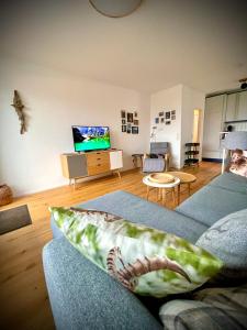 ein Wohnzimmer mit einem Sofa und einem TV in der Unterkunft Zeit für Dich am Bergelchen, Winterberg in Winterberg