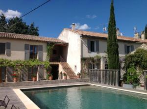 a house with a swimming pool in front of a house at Mas des Tourterelles in Saint-Rémy-de-Provence