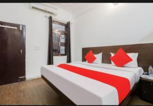 a bedroom with a large bed with red pillows at Welcome Guest Accommodation in Kolkata