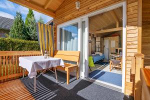 um alpendre com uma mesa e uma porta de vidro deslizante em Tiny-Ferienhäusle Casa Wendy em Loßburg