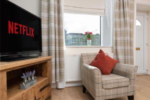 a living room with a television and a chair at Durham house in Sheepscar