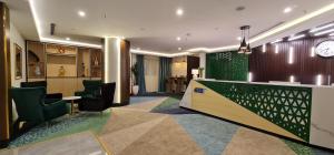 un vestíbulo con bar, sillas y reloj en Signature Hotel, en Yeda