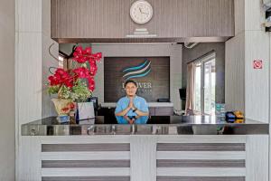 Un homme dans un bureau avec une horloge sur le mur dans l'établissement OYO 90777 D’river Guest House, à Bandung