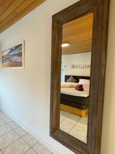 einen Spiegel an der Wand in einem Zimmer mit einem Bett in der Unterkunft Wohnen beim Brotsommelier - Holzmichel in Darmstadt