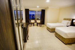 a hotel room with two beds and a table at AQABA COAST HOTEL in Aqaba