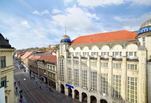 a large building with a red roof on a city street at Agape Main Square Apartment in Zagreb