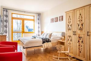 ザコパネにあるPrestige Apartamenty Krupowki 36/9のベッドルーム1室(ベッド1台、赤い椅子付)