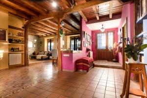 uma sala de estar com paredes cor-de-rosa e tectos em madeira em Casa Rural La Moderna em La Parrilla