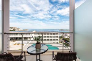 巴利恩的住宿－Atali Grand Resort，阳台配有桌椅,享有海景。