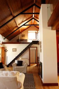 uma sala de estar com mobiliário branco e uma escadaria em Quinta Dos Anjos em Santarém