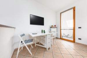 Zimmer mit einem Schreibtisch und einem TV an der Wand in der Unterkunft Casa da Suite Rho in Rho