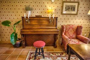 a living room with a piano and a chair at Hotel Colonial de Santillana in Santillana del Mar