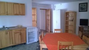 a kitchen and dining room with a table and chairs at Villa Giulia Vendégház in Verpelét