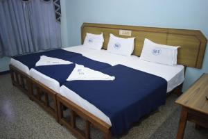 a large bed with blue and white sheets and pillows at Sri Krishna Vilas in Coimbatore