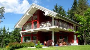 una casa roja con balcón en la parte superior. en Ferienhaus Melita, en Bleiburg