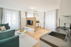 a living room with a blue couch and a kitchen at EH Apartments Neptun in Chur