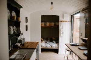 a small kitchen with a bed in a room at Angela's Rest Shepherds Hut with Scandi Hot Tub in Boston