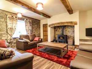 a living room with couches and a fireplace at Bodaioch Cottage in Caersws