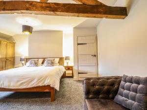 ein Schlafzimmer mit einem Bett und einer Couch in der Unterkunft Bodaioch Cottage in Caersws