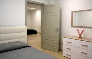 a bedroom with a bed and a mirror and a dresser at Dea Igea Apartment in Bellaria-Igea Marina