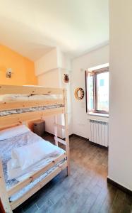 sypialnia z dwoma łóżkami piętrowymi i oknem w obiekcie La casa di Olivia w mieście Rocca di Cambio