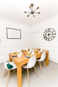 Un comedor con una mesa de madera y sillas blancas. en Beautiful City-Centre Townhouse with Hot Tub, en Norwich