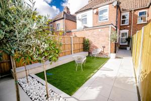 un pequeño jardín con césped y una valla en Beautiful City-Centre Townhouse with Hot Tub, en Norwich