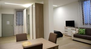 a living room with a table and a couch and a television at Dea Igea Apartment in Bellaria-Igea Marina