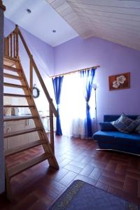 a living room with a staircase and a blue couch at Waldi Pokoje Gościne z aneksem in Karpacz