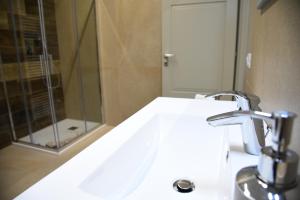 ein Badezimmer mit einem weißen Waschbecken und einer Dusche in der Unterkunft Dea Igea Apartment in Bellaria-Igea Marina